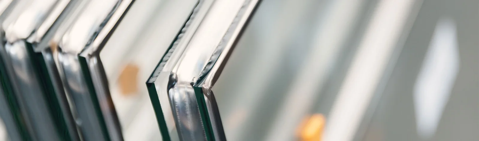 Polished edges of cut toughened glass panes stacked at the workshop